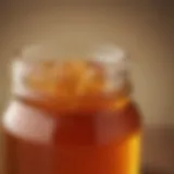 A close-up of honey in a glass jar with a subtle warm glow.